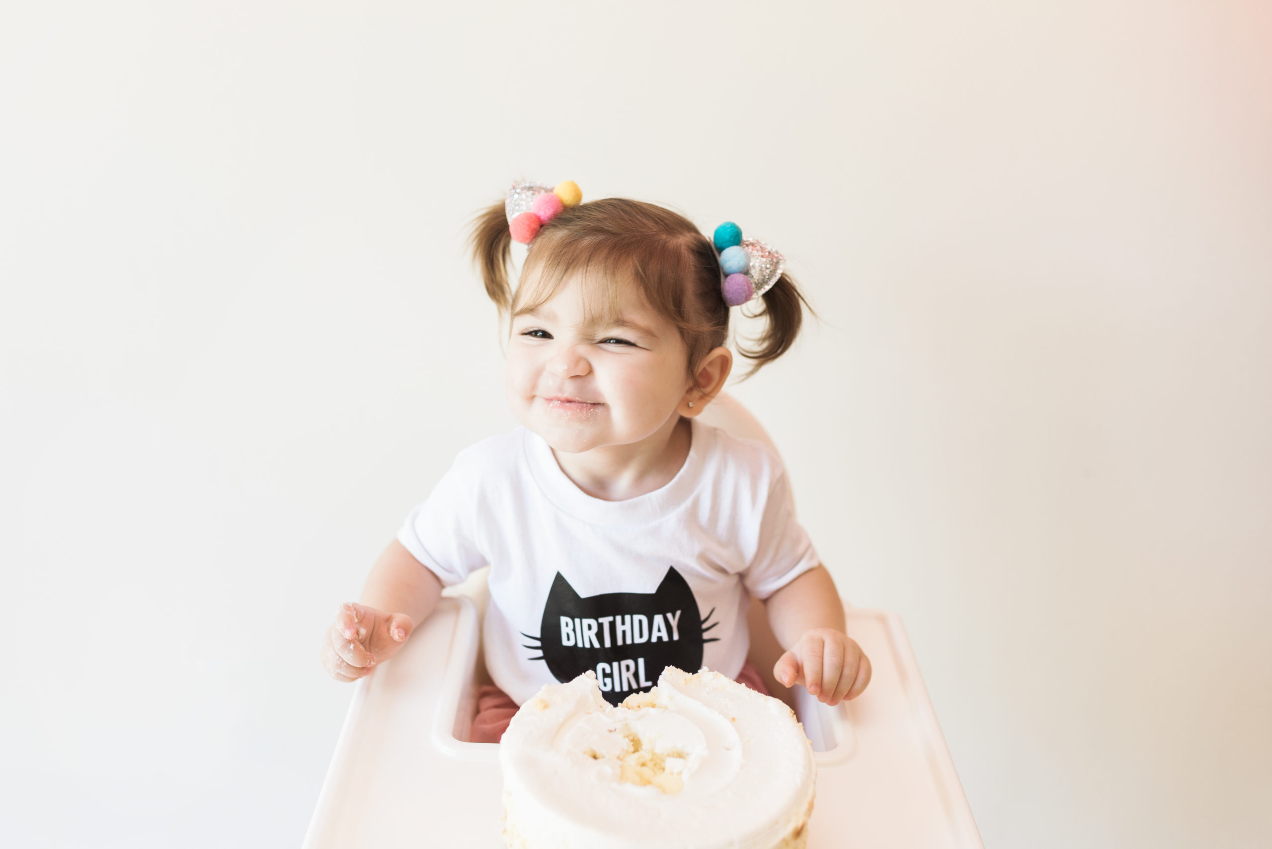 child grinning as they eat cake for their birthday