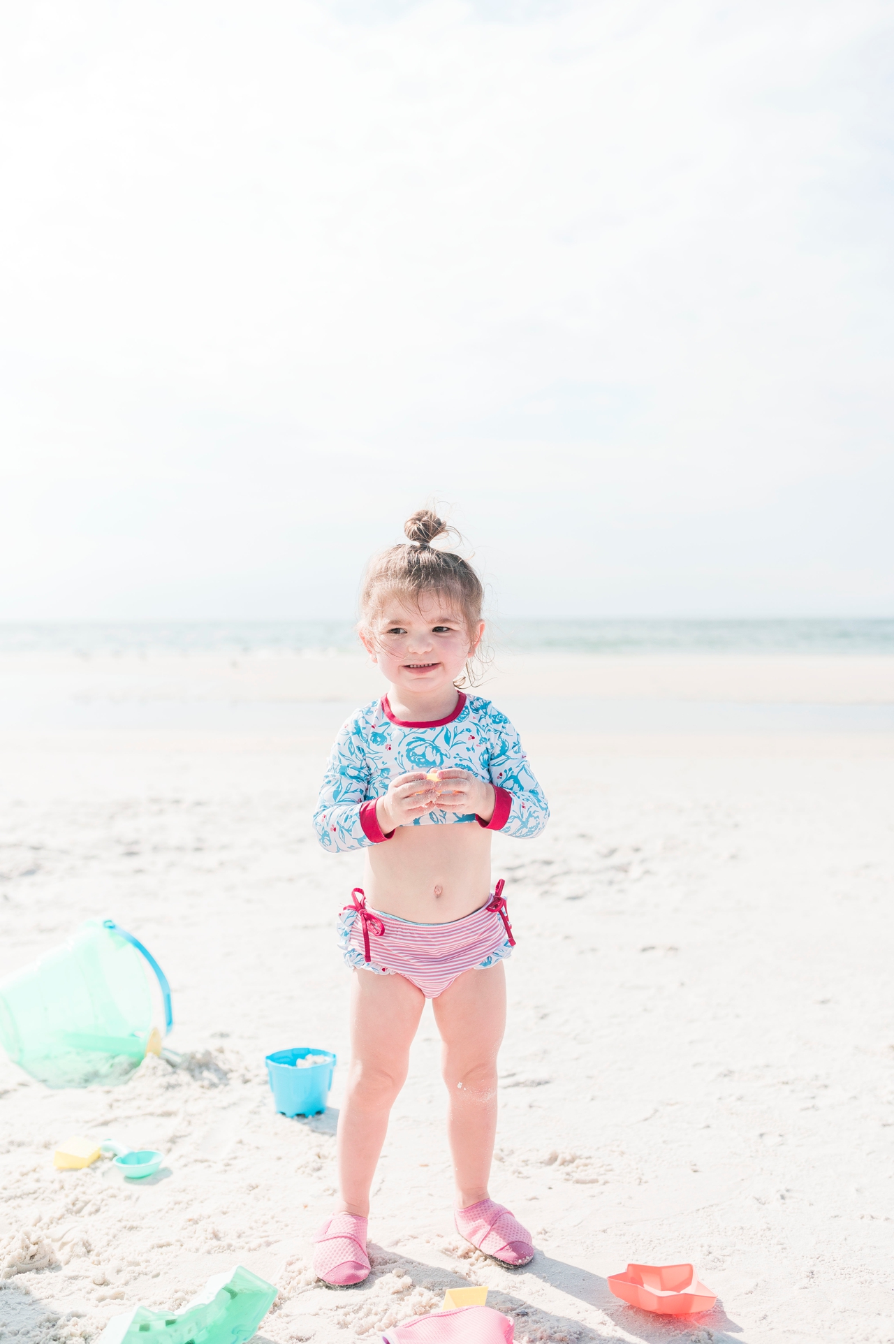 little girl playing with sand toys on beach in gulf shores alabama