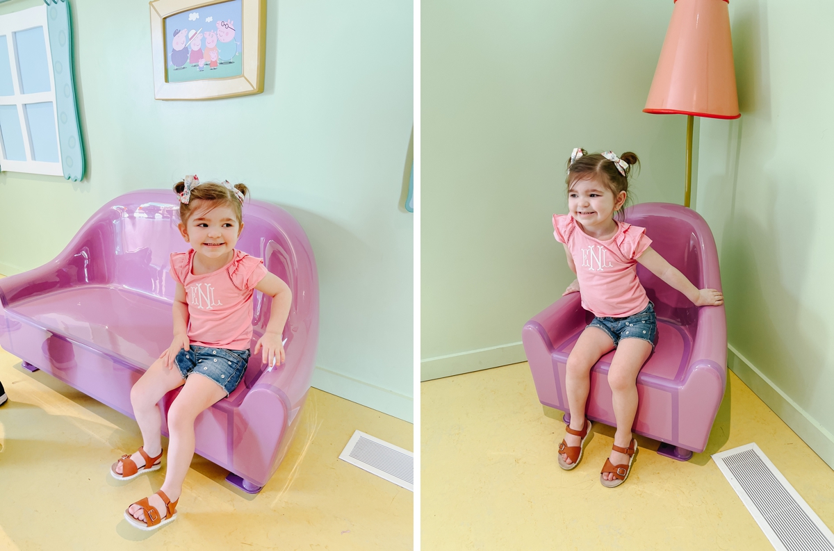 little girl with pig tails sitting on purple chair/couch in peppa pigs house