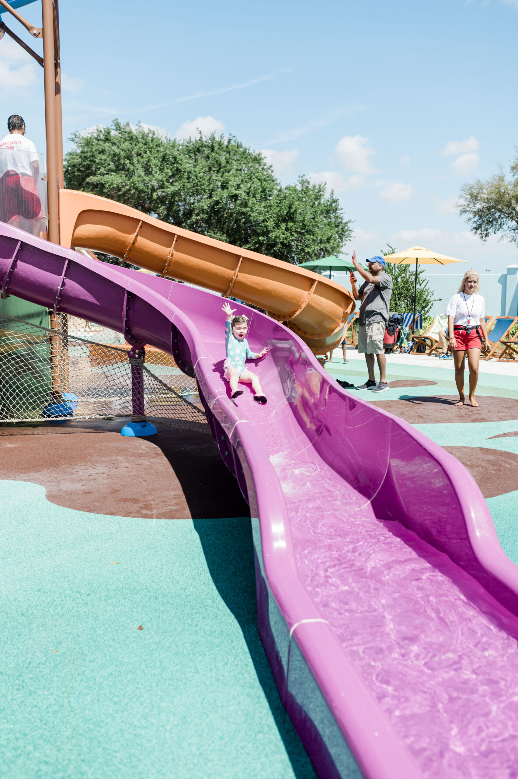 toddler going down pink water slide at peppa pig theme park florida