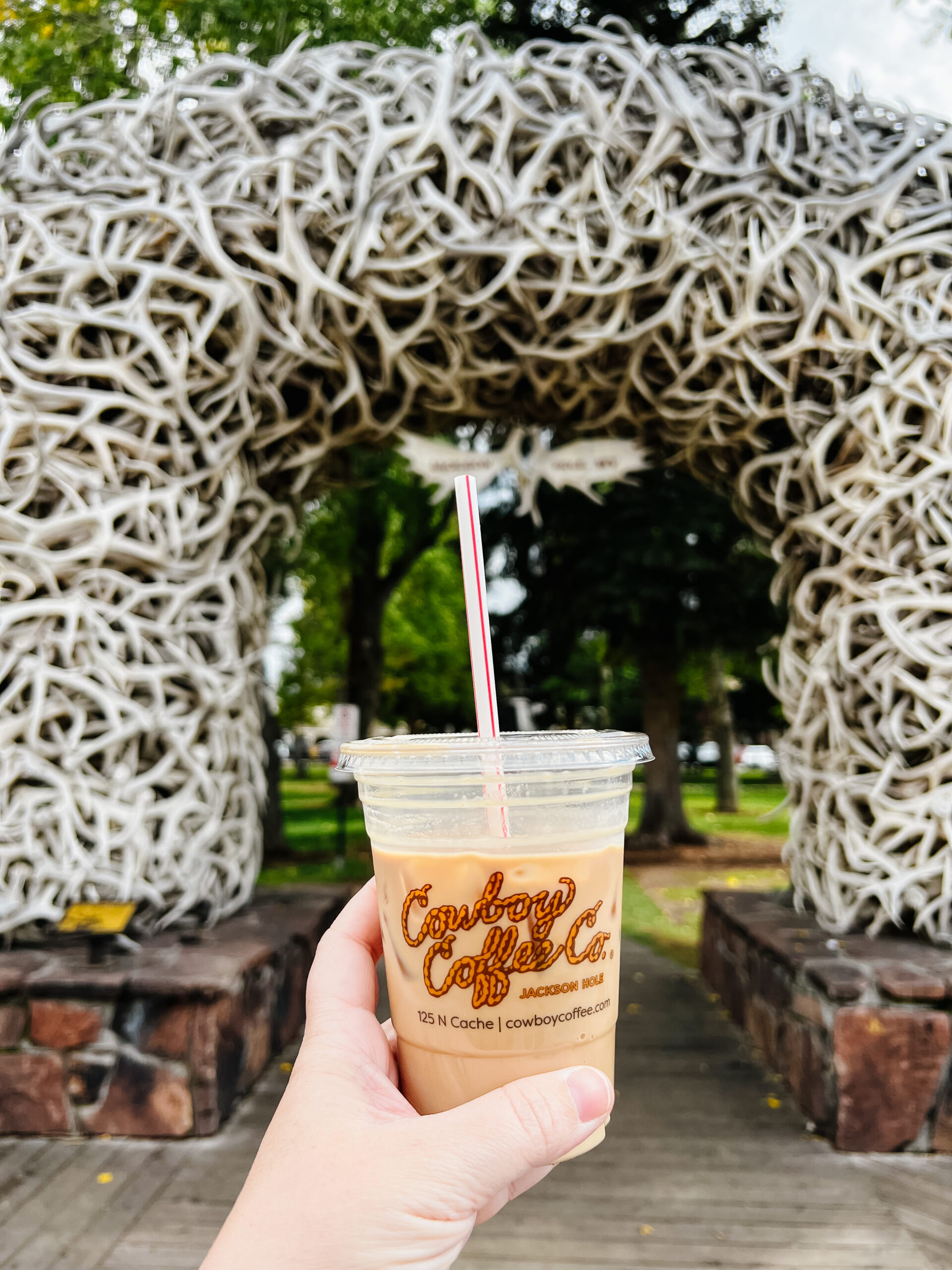 holding cup in the air from Cowboy Coffee Co in Jackson Square