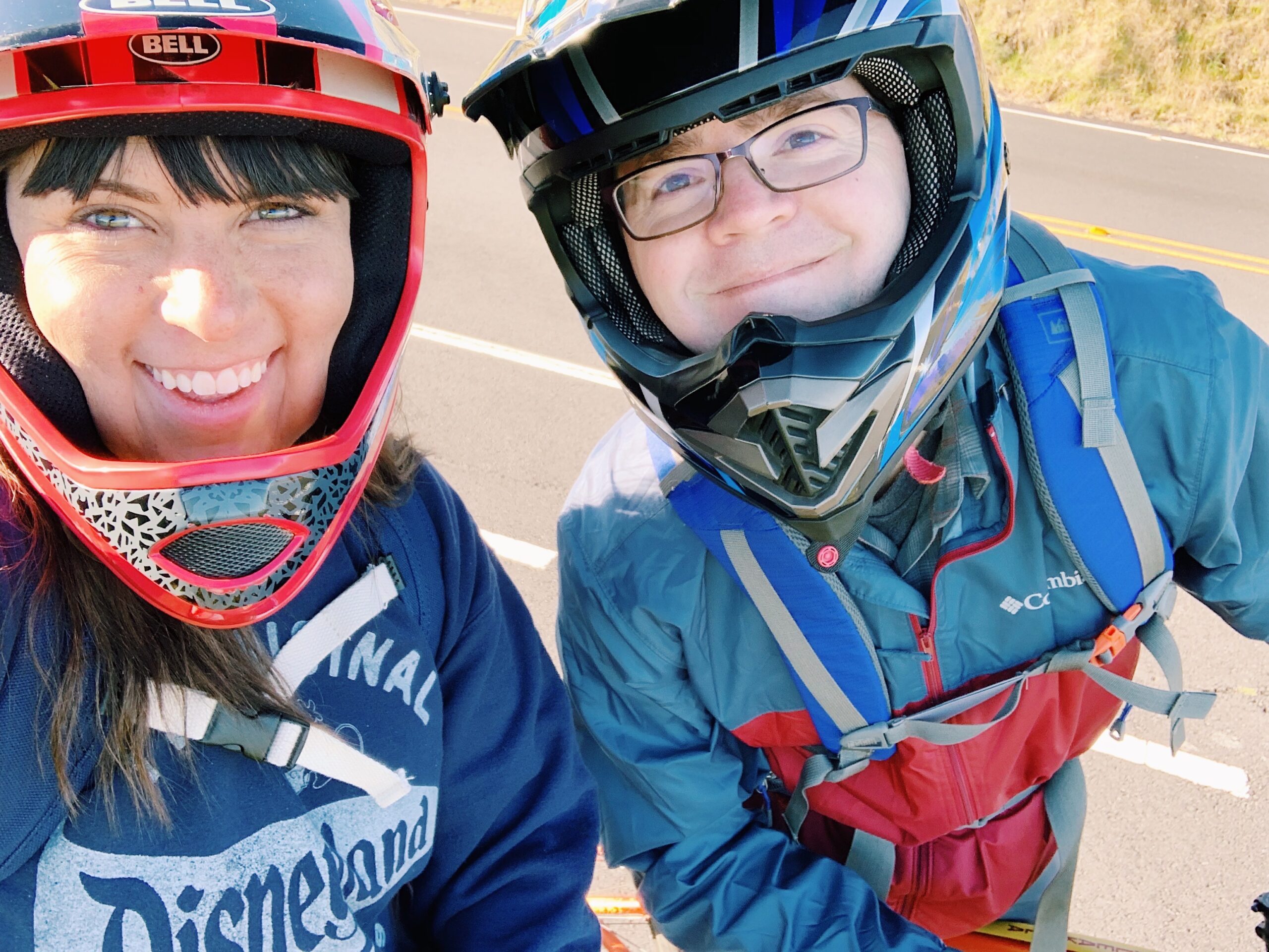 John and Brittney Naylor in bike helmets on bikes as they bike down Haleakala National Park Maui Hawaii