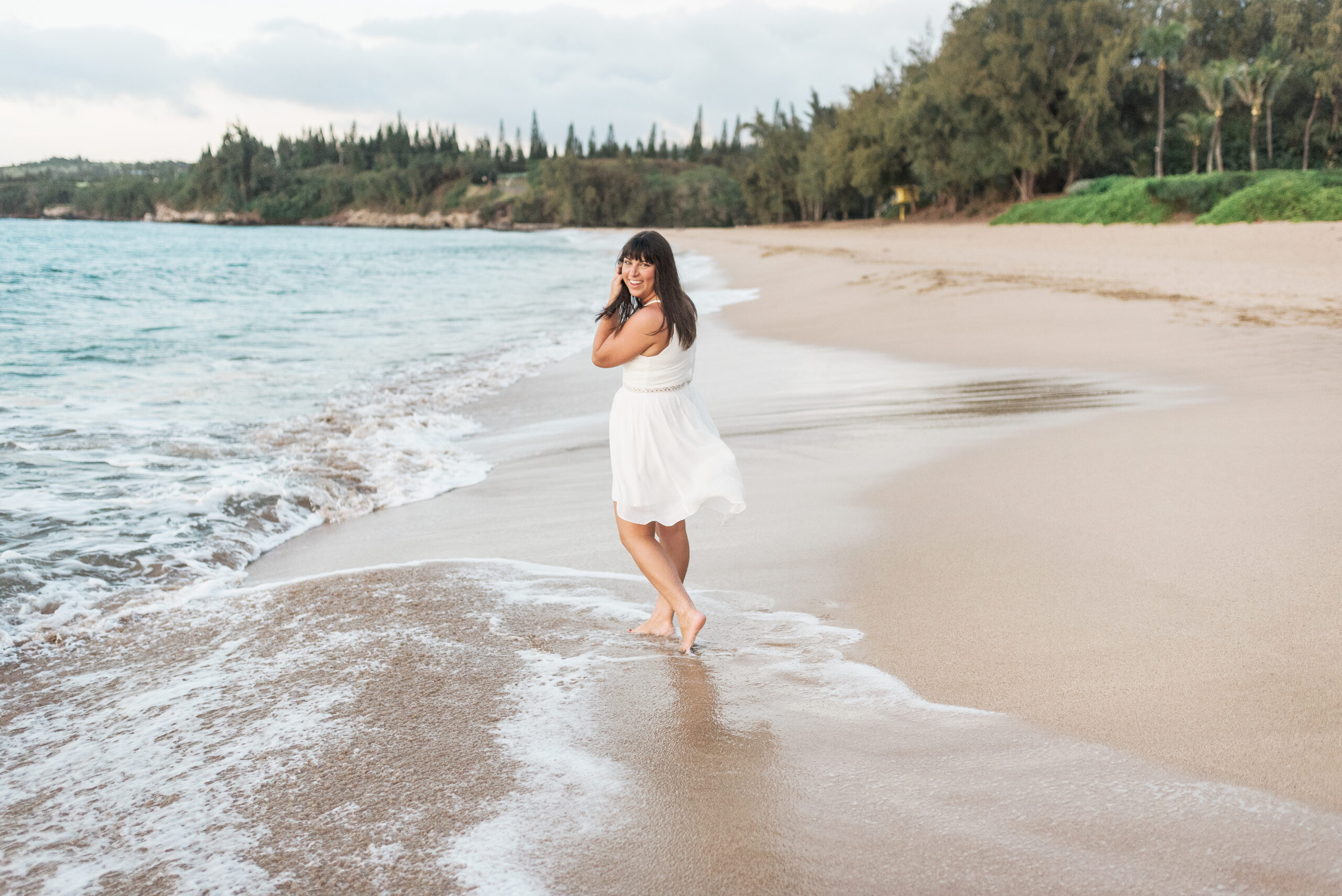 Brittney Naylor wearing white dress walking on the sandy beaches of Maui Hawaii at Ritz Carlton Maui. Maui with adventure.