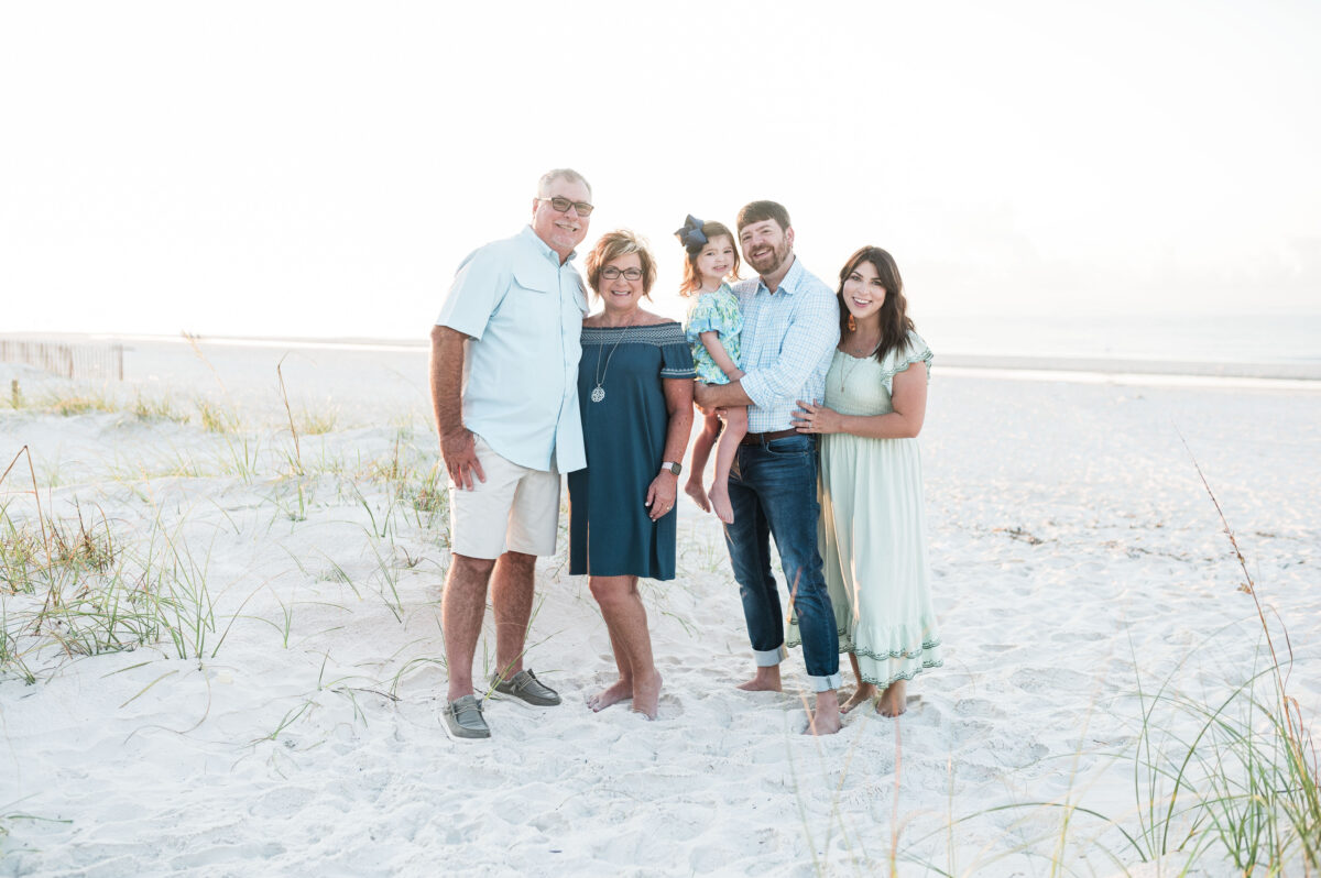 Naylor and Creech family posing together on the beach of Gulf Shores, Alabama. Family is coordinating in green/blue outfits. 3 Best Beach Destinations