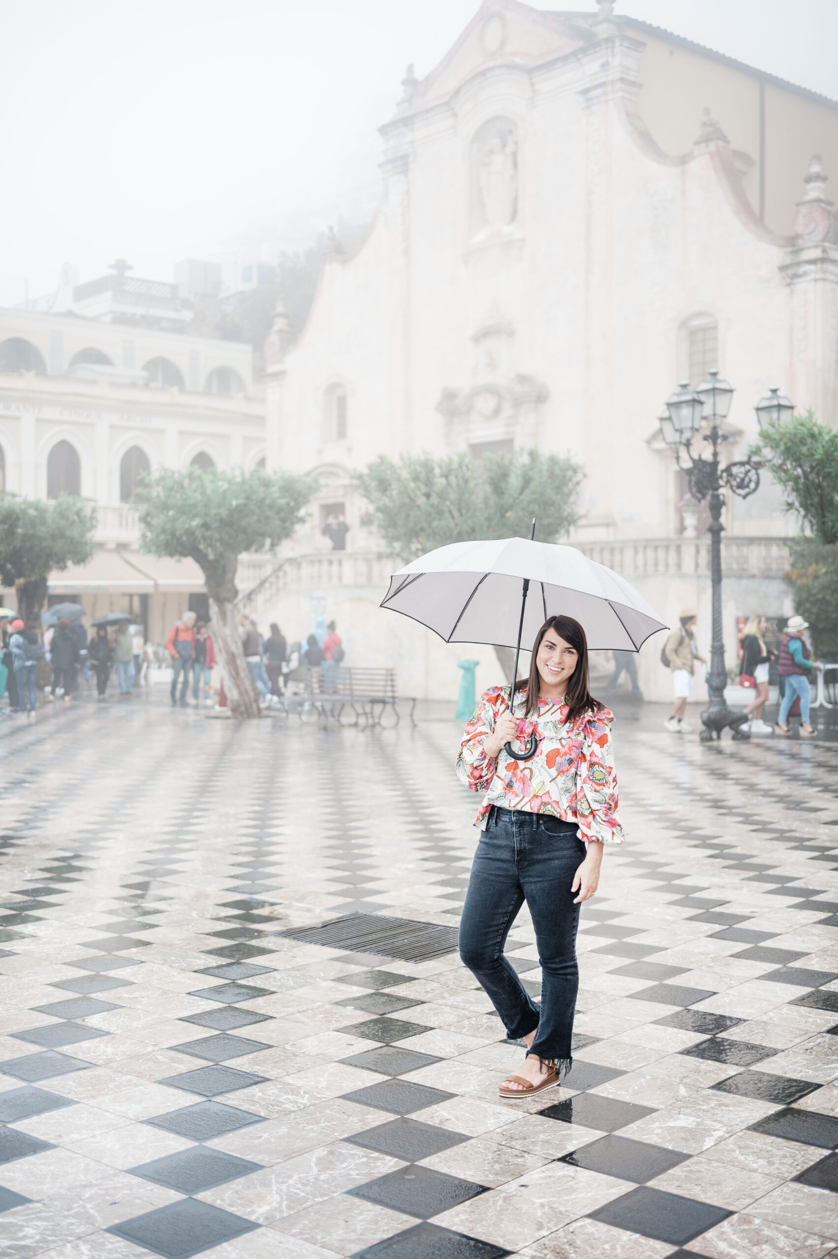 Brittney Naylor holding umbrella as it rains in Taormina, Sicily