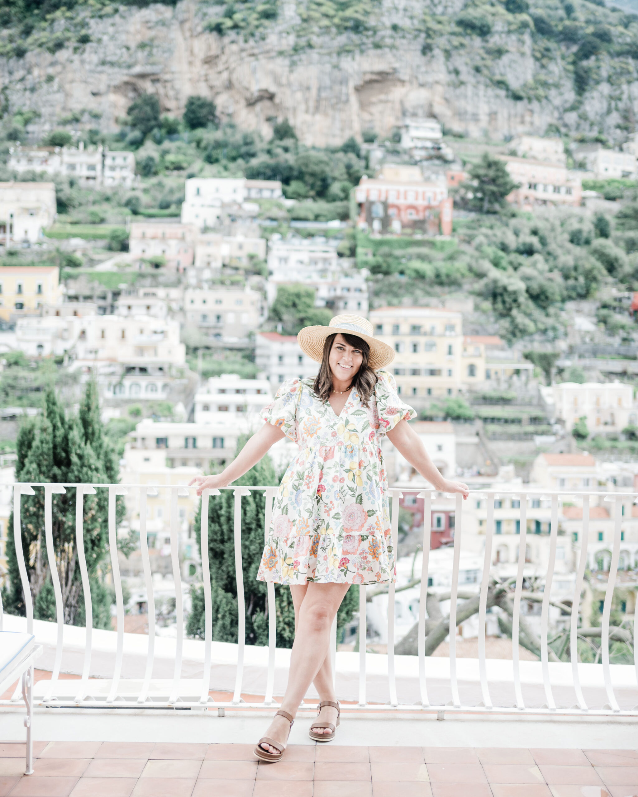 Brittney Naylor leaning on railing on her balcony of the Hotel Poseidon in Positano Italy