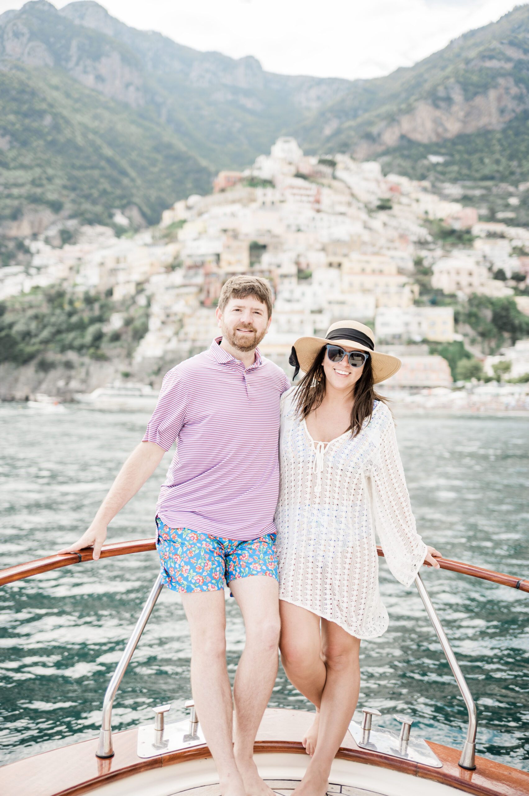 John and Brittney Naylor posing on private boat with Positano behind them