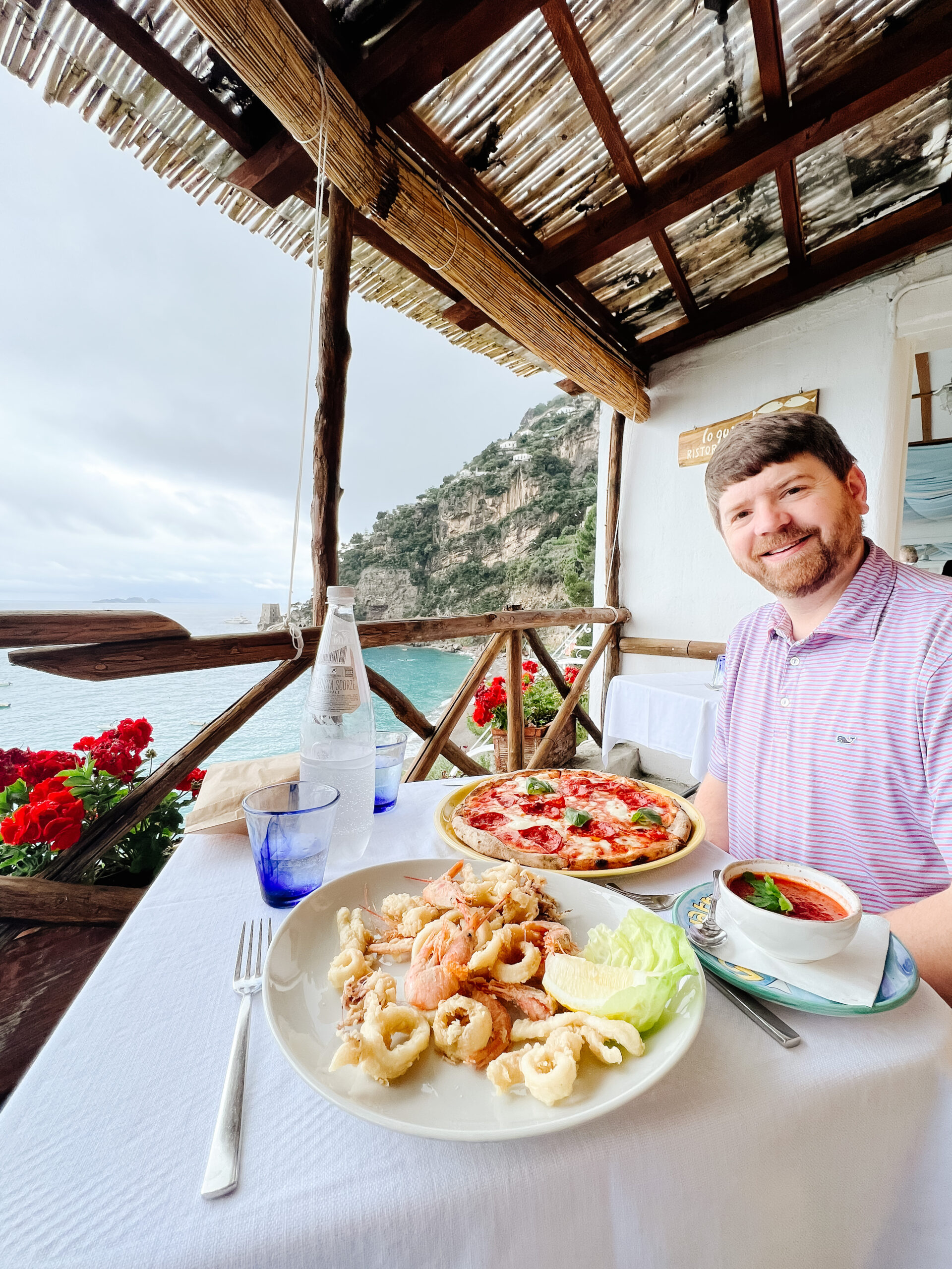 John Naylor with food at Lo Guarracino in Positano, Italy, eating pizza and fried calamari and fried prawn