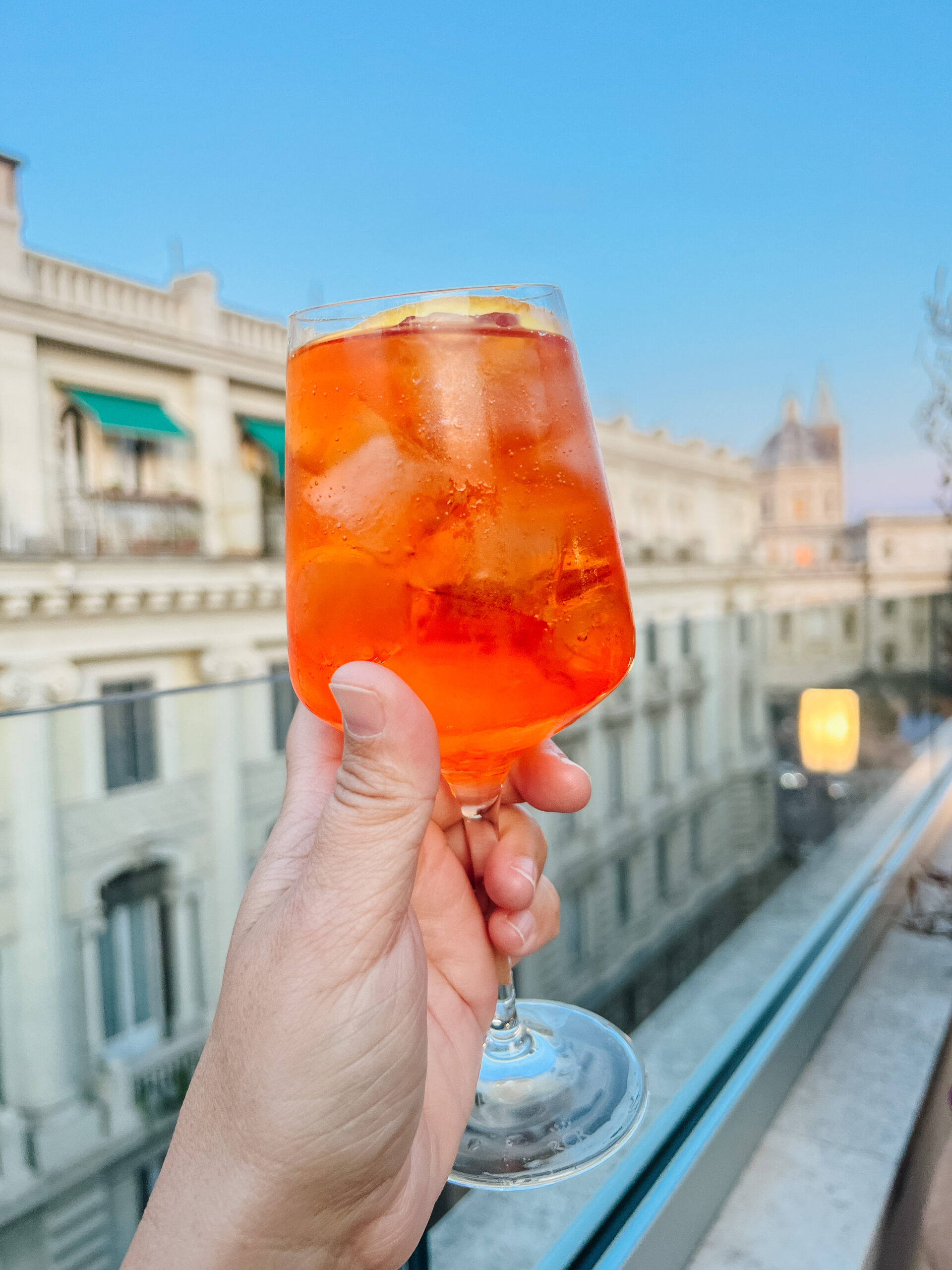 Cheers with Aperol Spritz on a rooftop in Rome, Italy. 36 Hours in Rome. A Mom Well Traveled Blog.