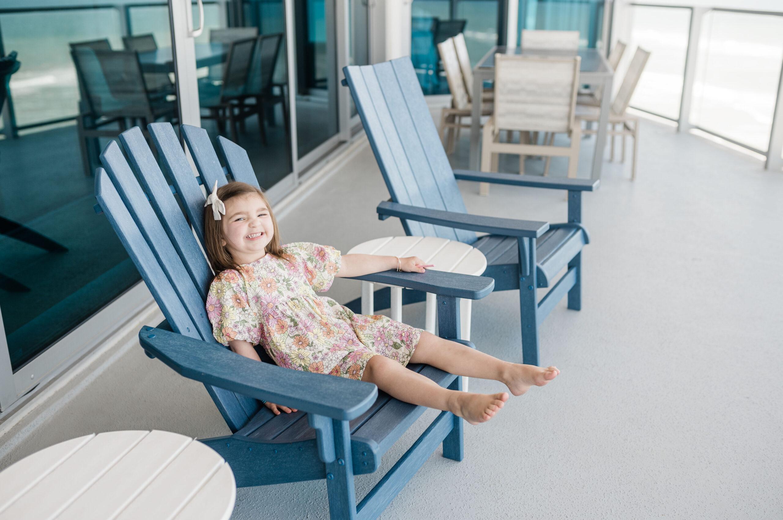 Eleanor Naylor siting in navy lounge chair on the balcony of Max Daytona Beach Resort--florida family-friendly resort