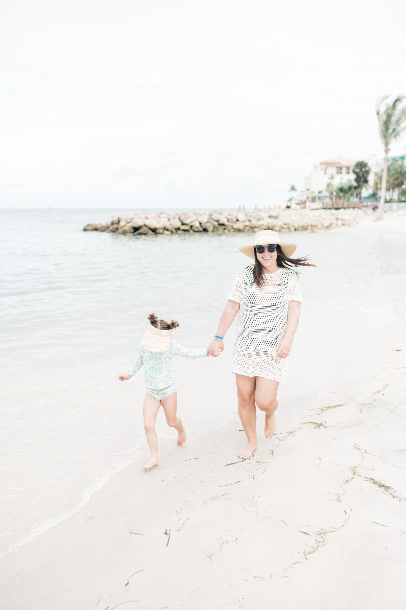 Brittney Naylor holding daughter's hand jogging on the best beach resort in Clearwater Beach, Florida.