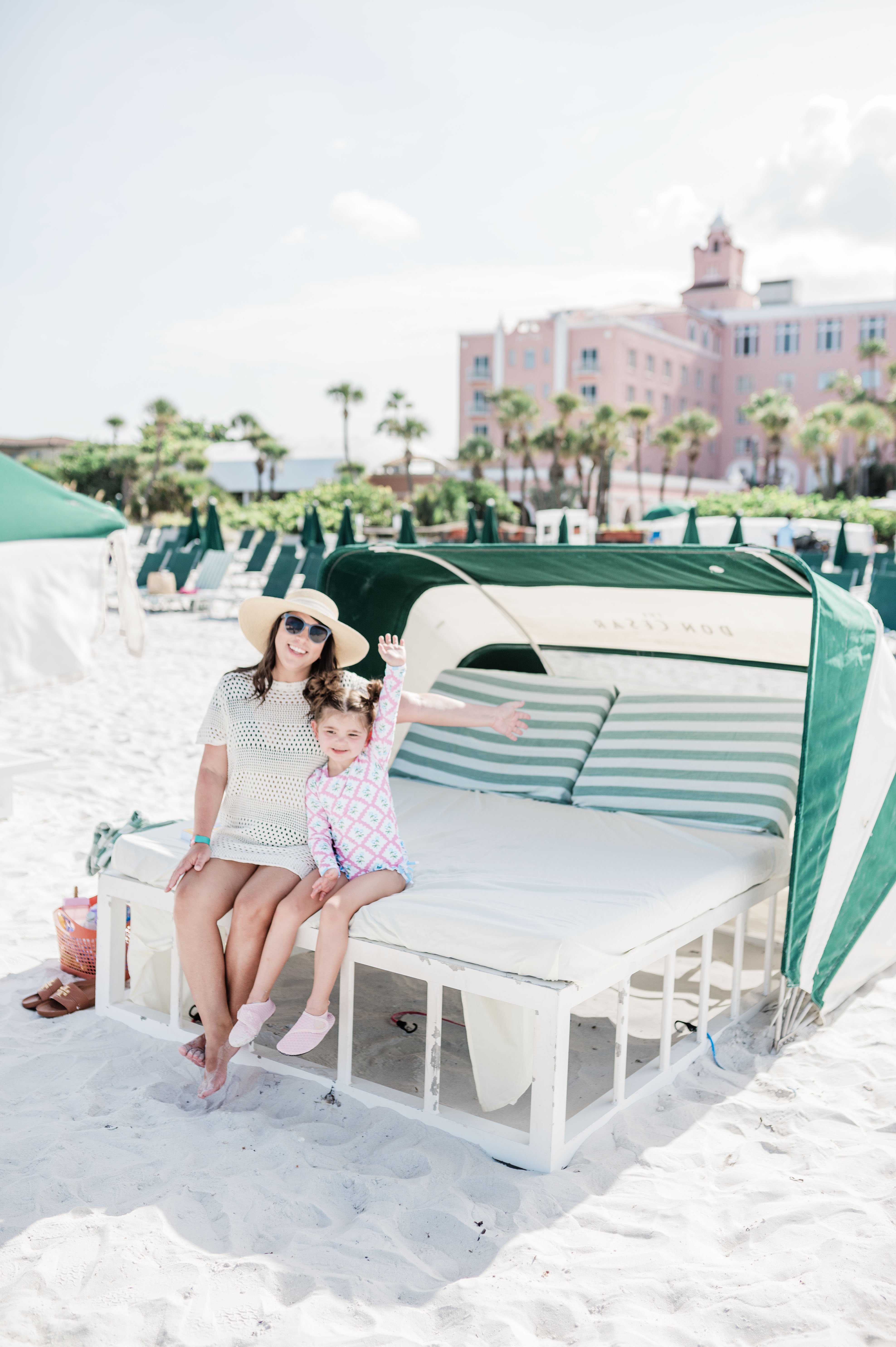 Brittney Naylor and daughter with their hands up as they sit in a cabana at The Don CeSar, Best family resorts in Florida