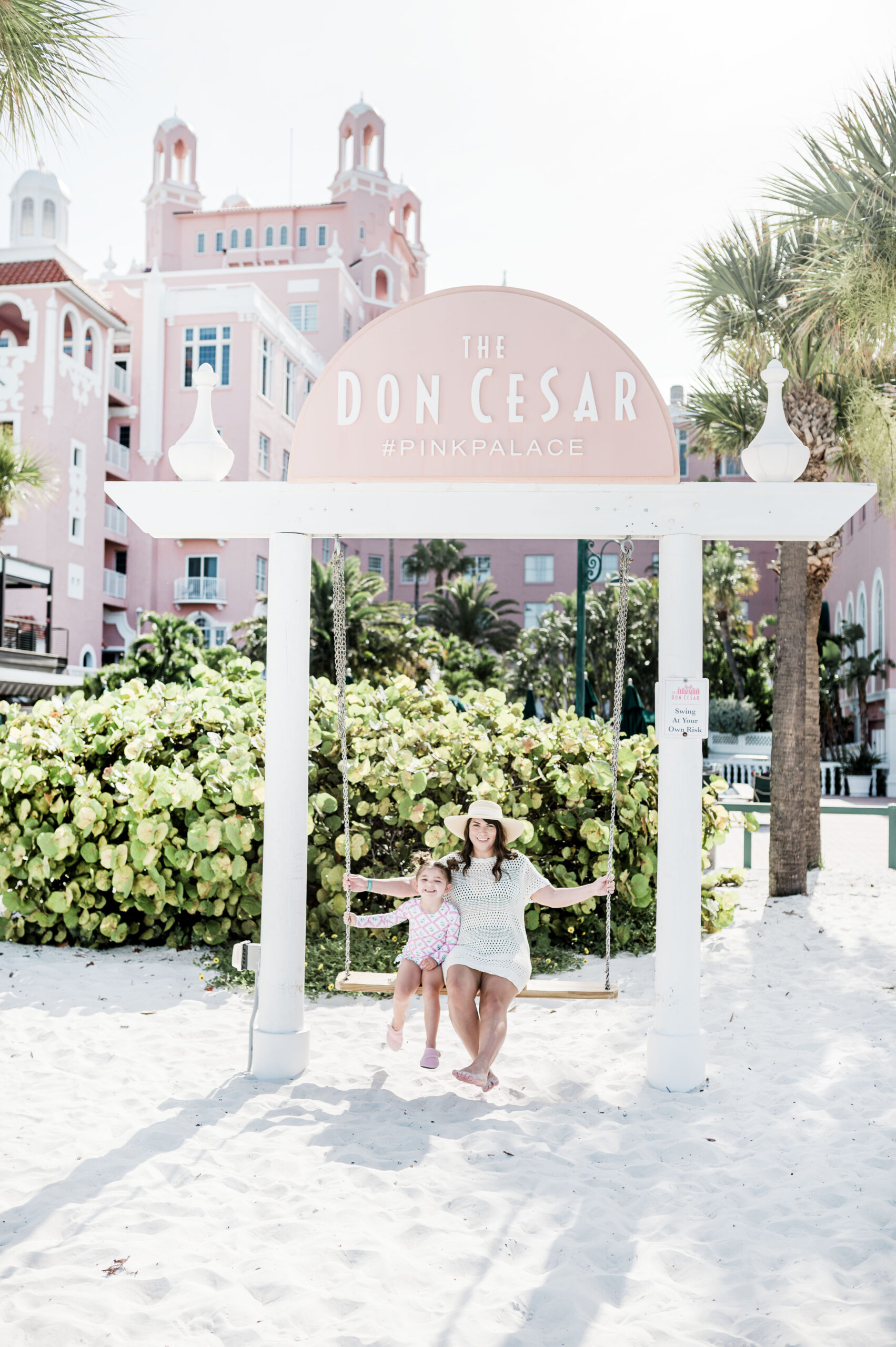 Brittney Naylor and daughter on swing at The Don CeSar hotel in Saint Pete. Instagrammable Hotel in Florida.