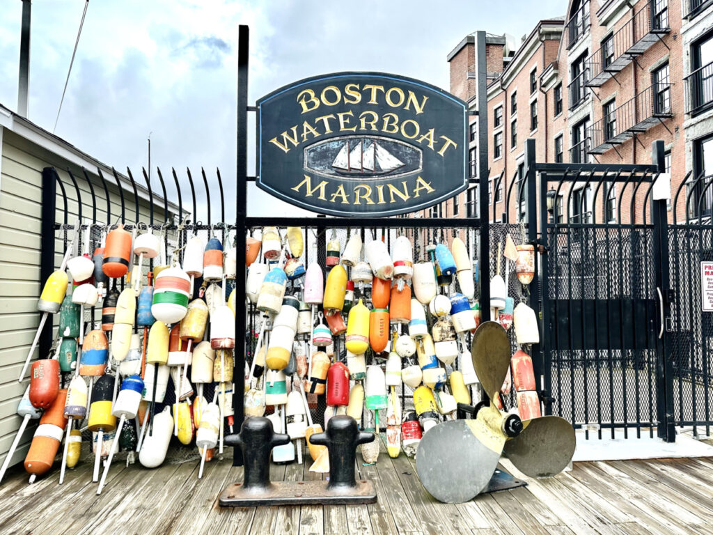 Boston Harbor sign with buoys on fence, image provided by Pri of Adventures for the Busy Soul