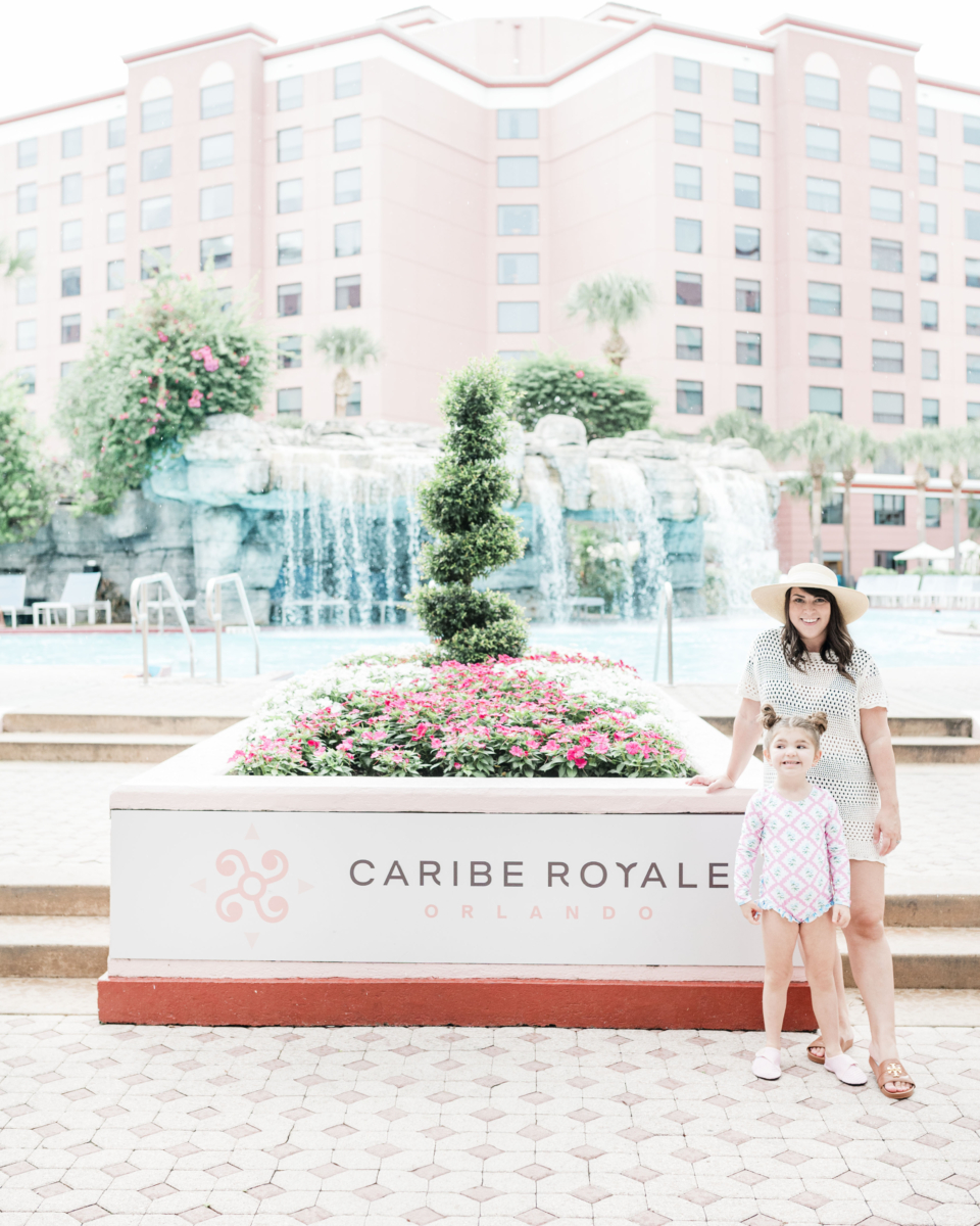 Brittney Naylor and daughter standing in front of the Caribe Royale sign at the pool at Caribe Royale in Orlando