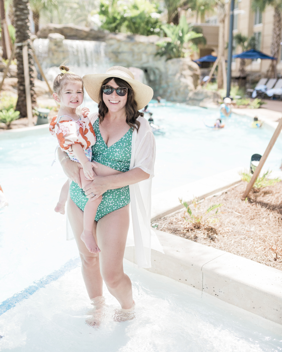 Brittney Naylor holding daughter while standing in the water of the Crystal River Rapids at Gaylord Palms in Kissimmee. Best Family Resorts in Florida.