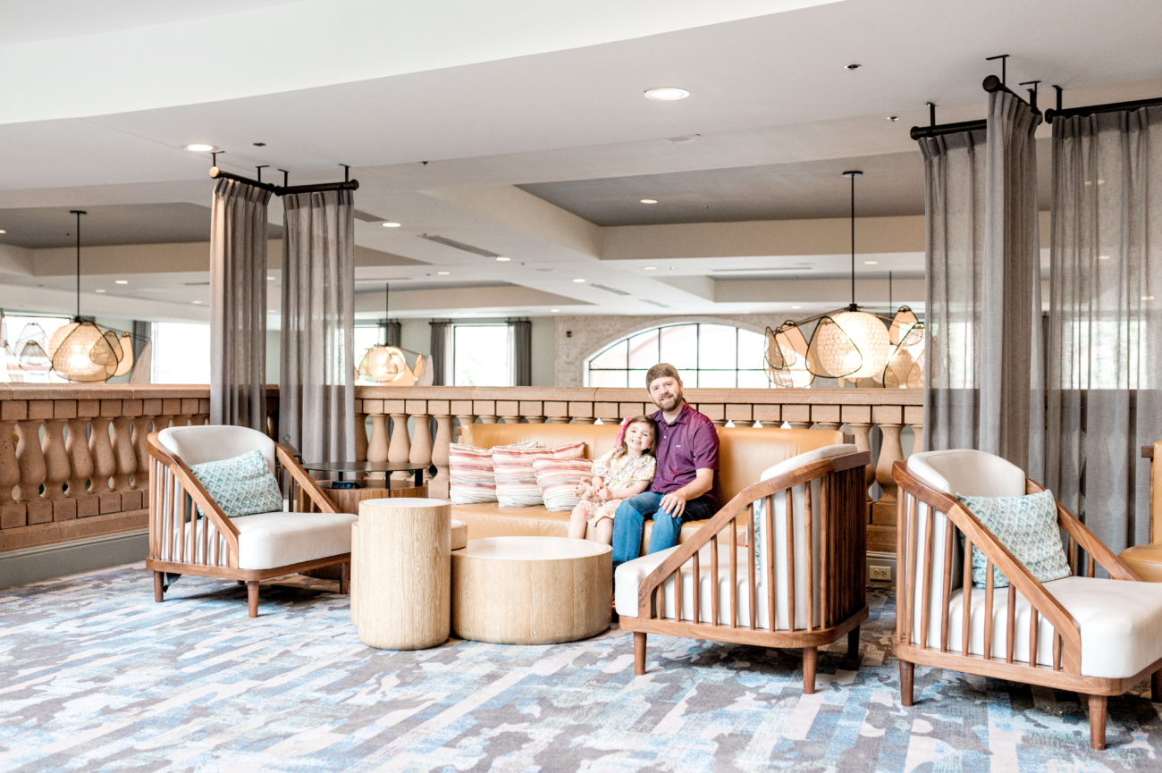 John Naylor and daughter sitting on couch in lobby area of Caribe Royale Orlando Florida