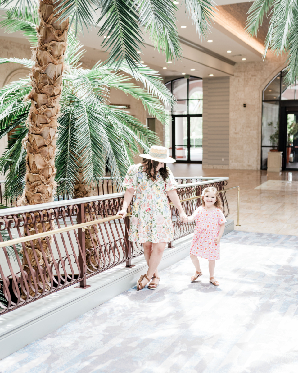 Brittney holding daughter's hand standing in the lobby of Caribe Royale Orlando