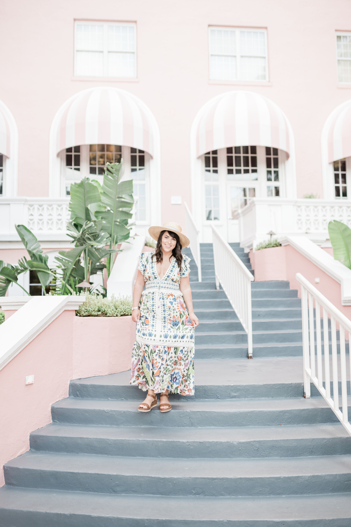 Brittney Naylor in long floral maxi dress walking down the stairs at The Don CeSar in Saint Pete. Most Instagrammable Hotel. The Pink Palace