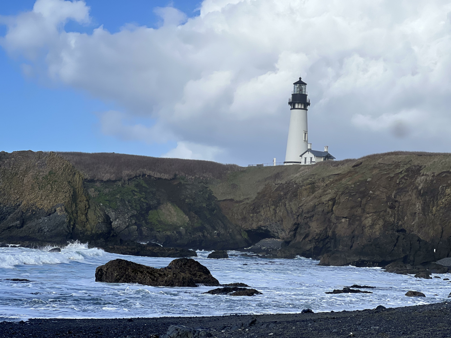 A lighthouse on top of a hill along the Oregon Coast--best places for spring break for families.