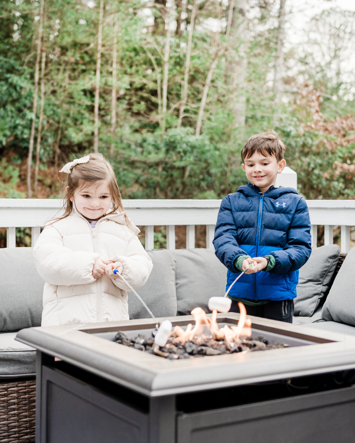 Two kids roasting marshmallows over a fire to make smores. An activity during your weekend in Helen, Georgia.