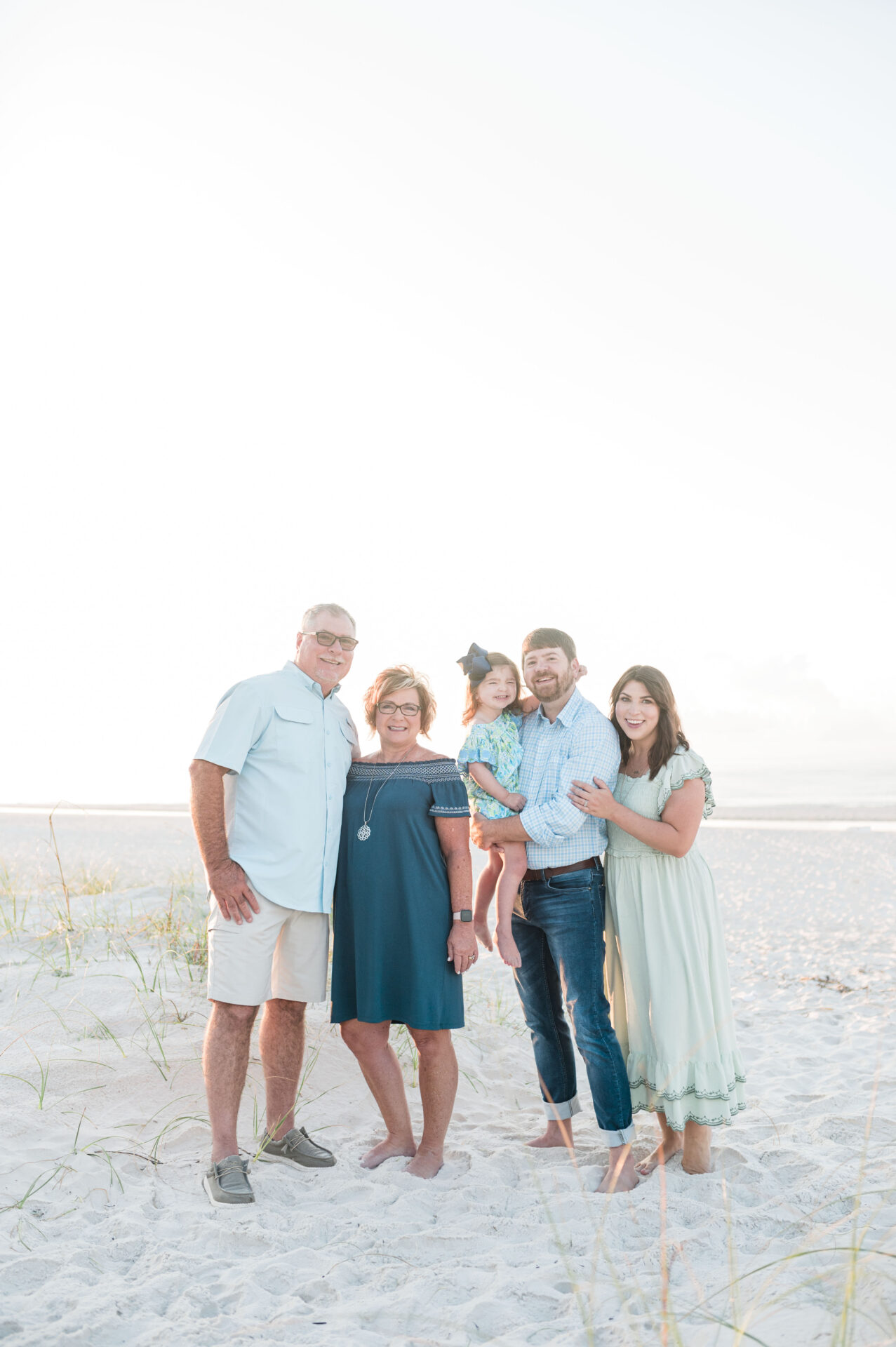 Multigenerational Travel Tips. Family of 5, three generations posed on the beach in Gulf Shores, Alabama
