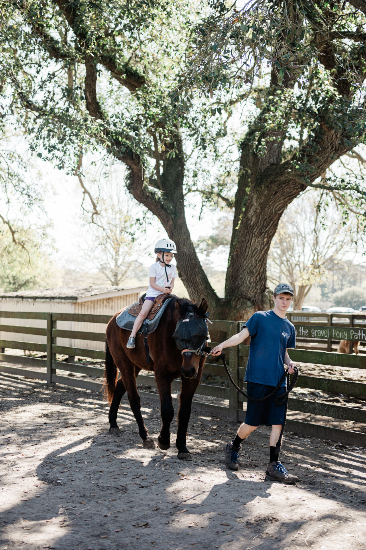 Emma riding brown horse as someone guides with the reigns at Lawton Stables in Hilton Head--Hilton Head family friendly activities