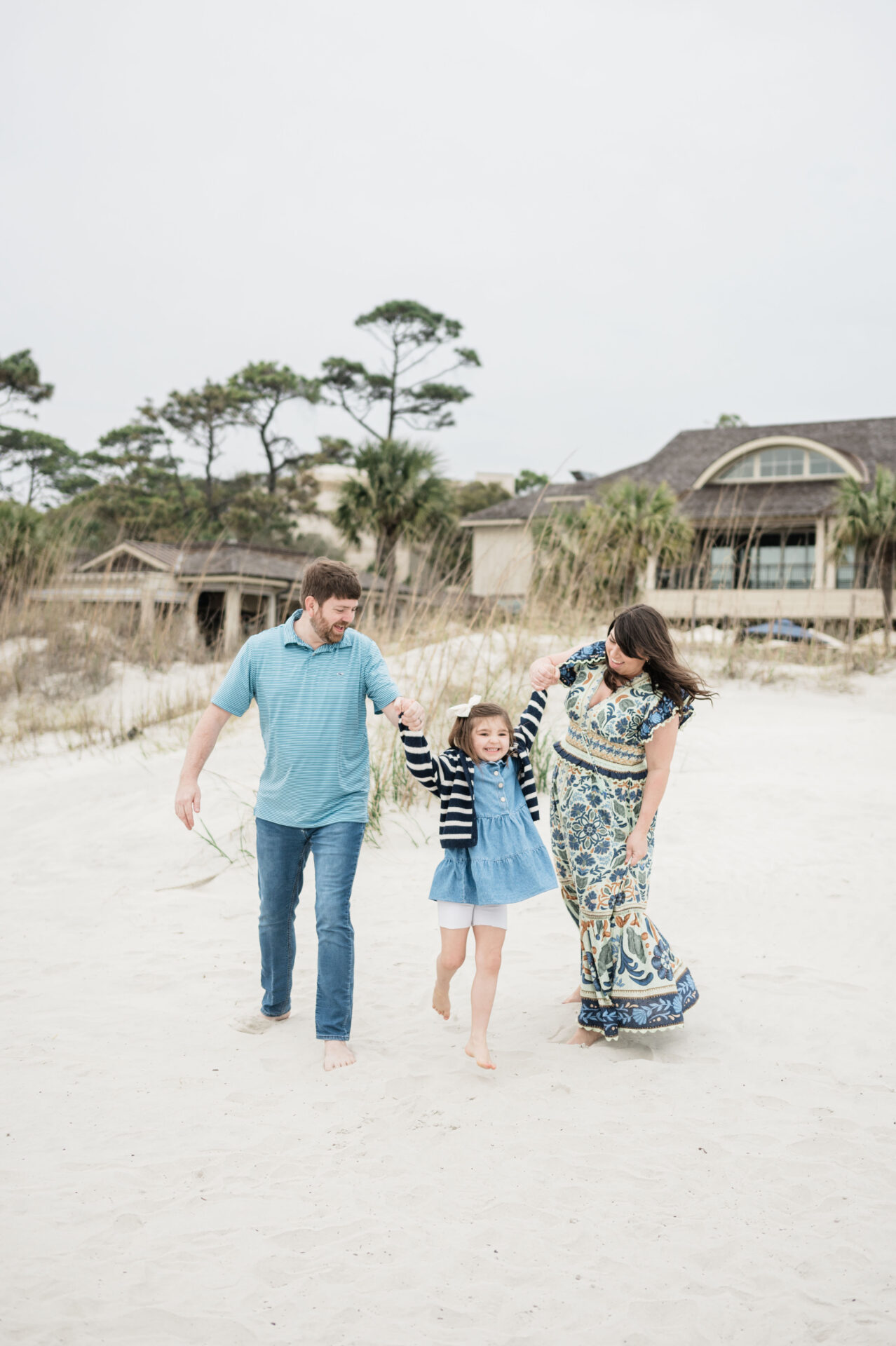 Naylor family holding hands and swinging daughter while on the beach in Hilton Head Island, South Carolina