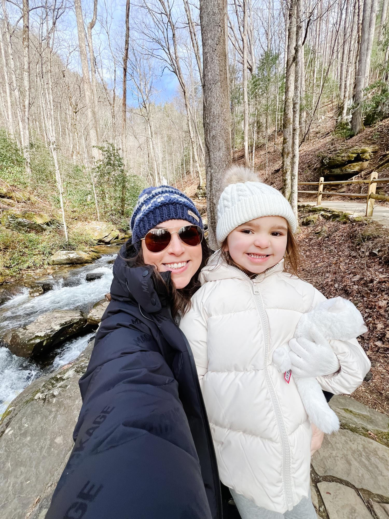 Brittney Naylor and daughter taking a selfie with creek and forest woods behind while standing on the trail toward Anna Ruby Falls--weekend in Helen, Georgia for families