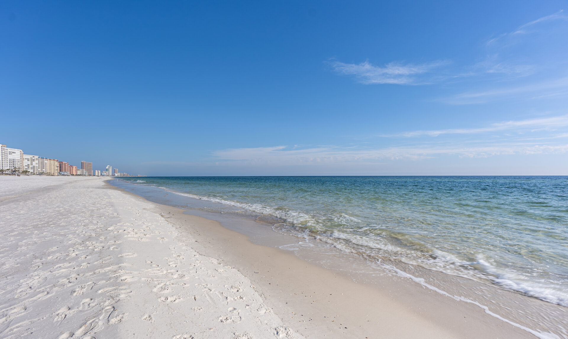 Gulf Shores shoreline with hotels in the distance, Photo courtesy of Gulf Shores & Orange Beach Tourism