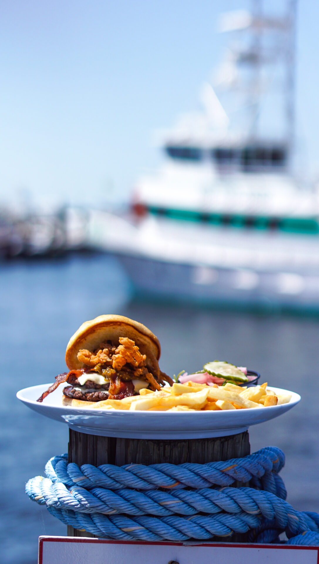 OSO at Bear Point Harbor--a plated meal featuring boats on the harbor in the distance--photo courtesy of Alabama Beaches Tourism, best restaurants in Orange Beach