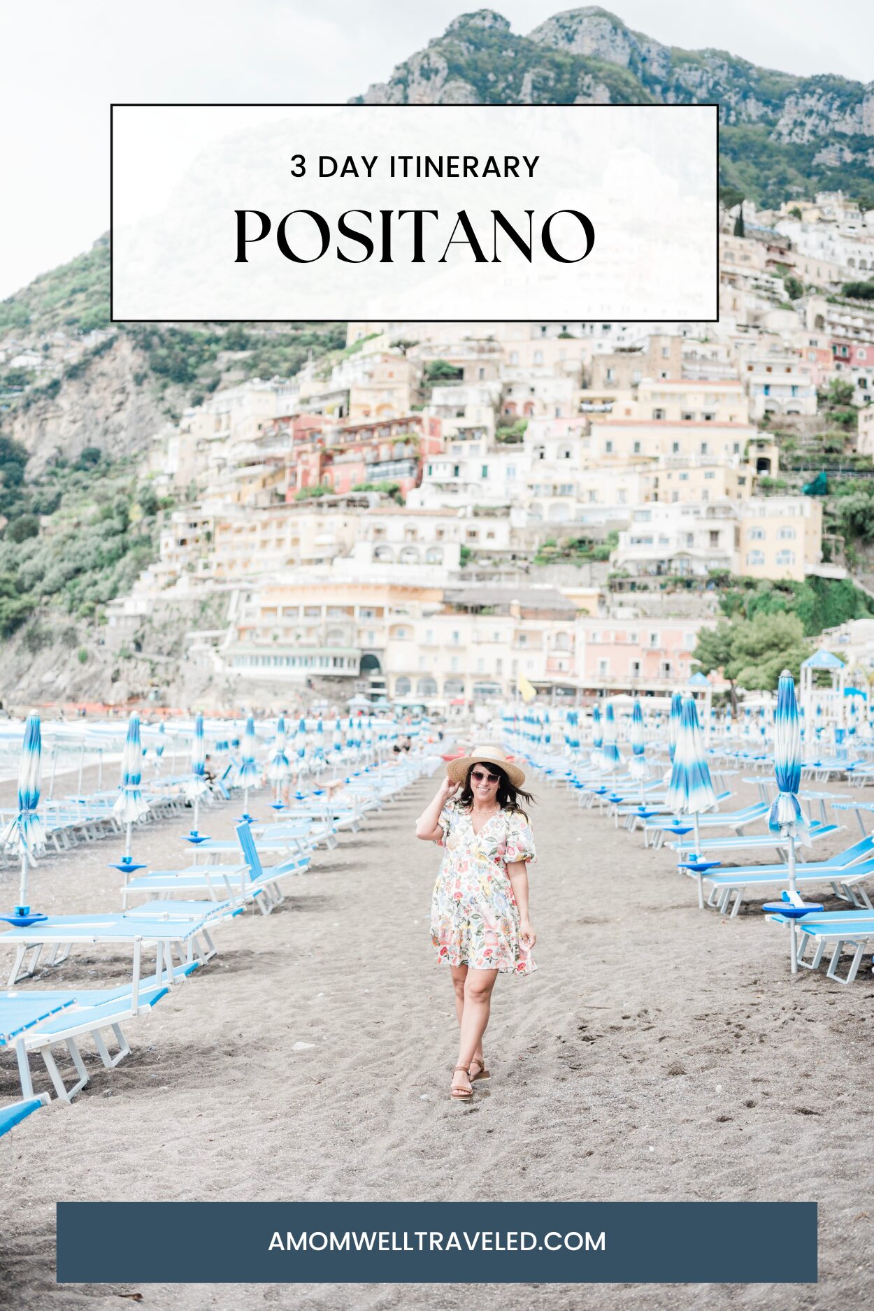 Brittney Naylor in a dress and hat standing on a beach with chairs and a hill in the background--Positano Beach