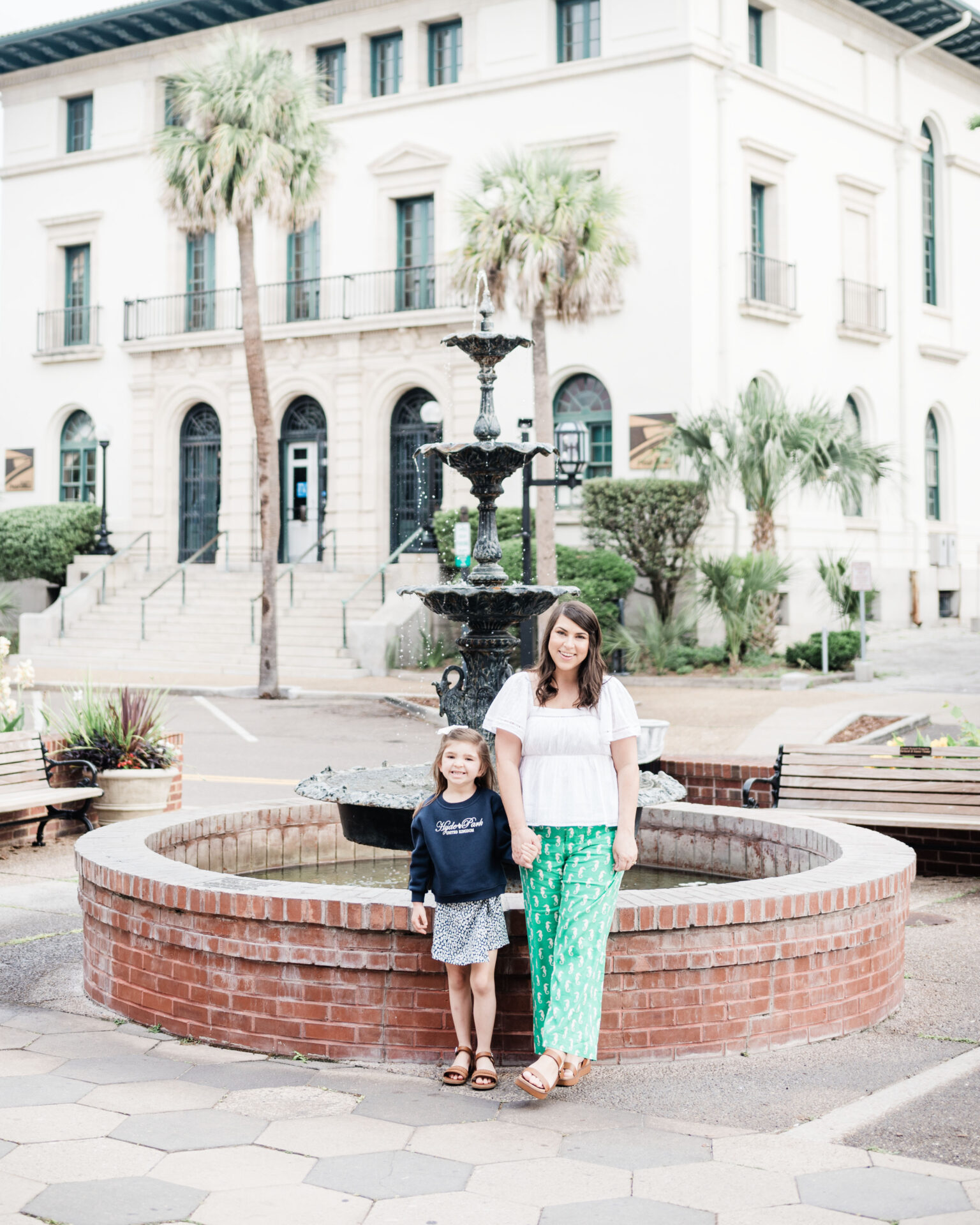 a woman and a girl posing for a picture in front of a fountain, downtown Amelia Island, family weekend in Amelia Island