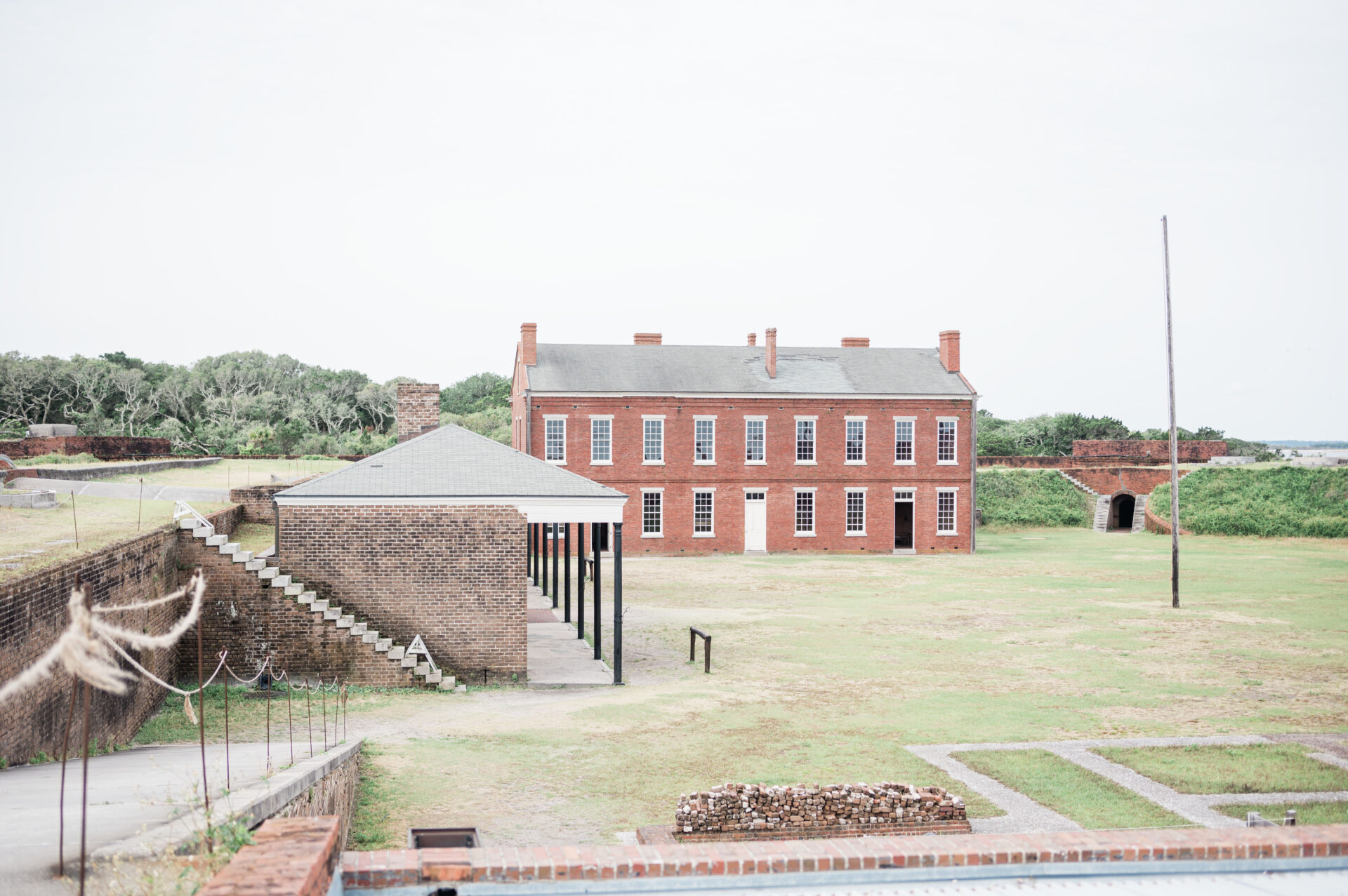 a brick building with a brick structure in the background from Fort Clinch State Park in Amelia Island