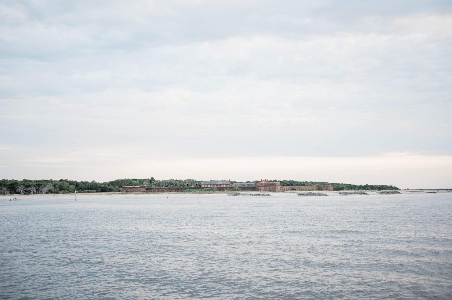 a body of water with buildings and trees, Fort Clinch from the inlet 