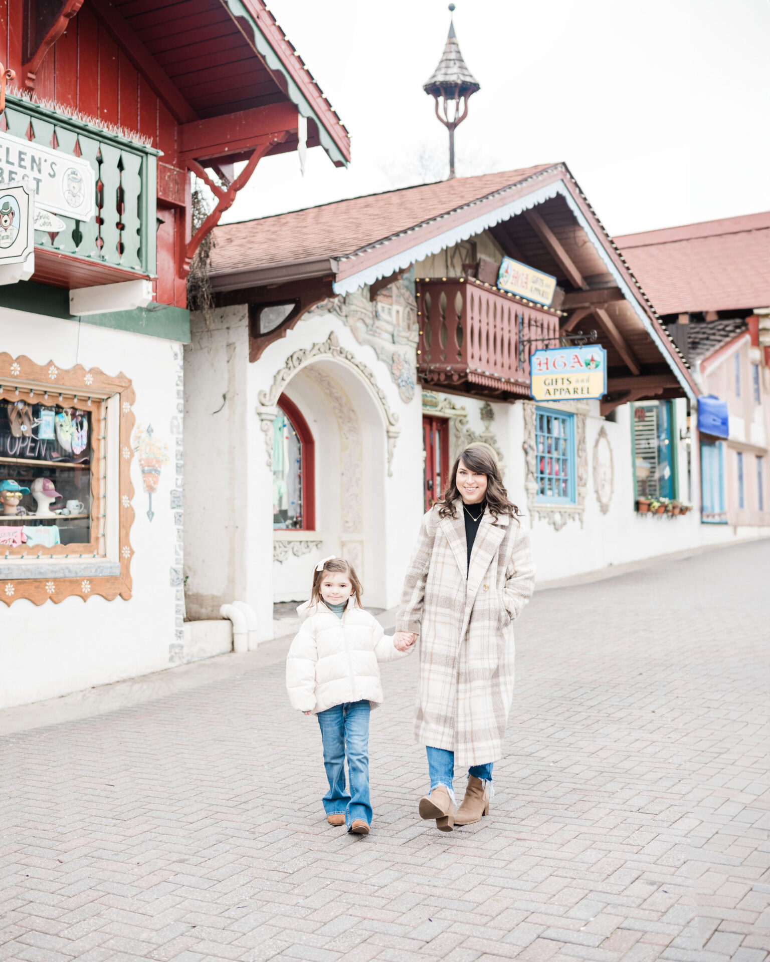 Brittney and daughter walking through downtown Helen, Georgia. Brittney is wearing a long pea coat rented from Rent the Runway