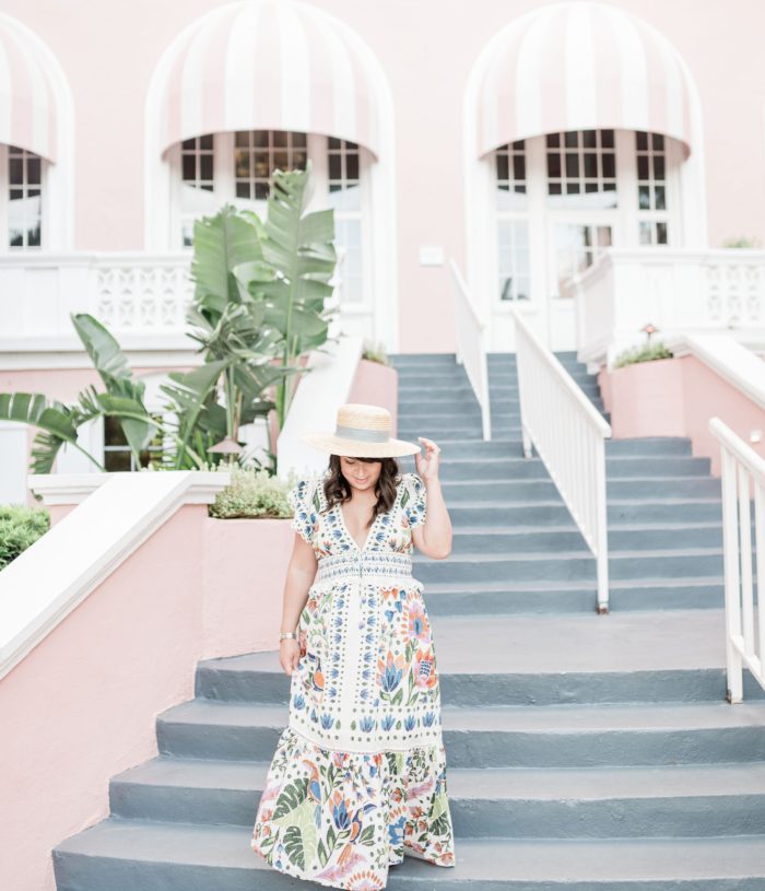 Brittney Naylor in Farm Rio floral maxi dress walking down stairs at the Don CeSar hotel in Saint Pete aka The Pink Palace. Most Instagrammable Hotel.