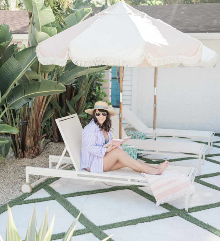 a woman sitting on a lounge chair under an umbrella, brittney naylor of a mom well traveled